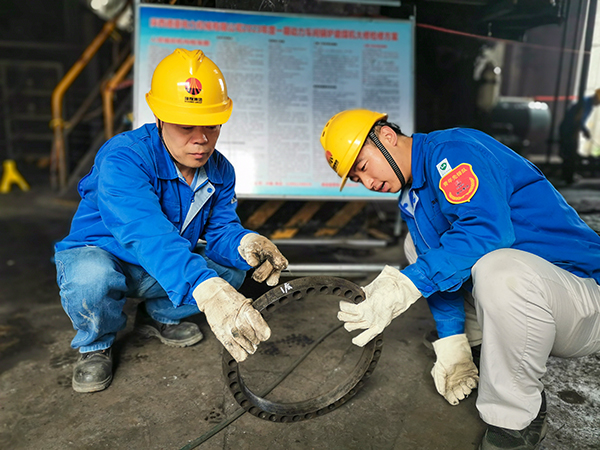 圖三：12日下午14時(shí)，在一期磨煤機(jī)廠房，陜西省技術(shù)能手姬霄給青工張跟潮講解磨煤機(jī)搖臂曲拐內(nèi)環(huán)及動(dòng)作原理。.jpg